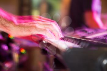 Musician plays keyboards in a rock band .