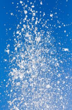 Splashing water against the blue sky. background