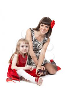 Family love of mother and daughter having fun embrace with happy laughter sitting on floor. A girl in a red dress, my mother in fashionable clothes and shoes to sunglasses.