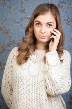 portrait of young woman talking using a telephone against a vintage background