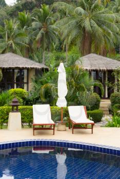 Bungalows and a swimming pool in tropical hotel