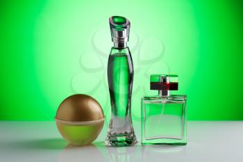 Three perfume bottle on a bright green background gradient.
