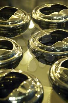 stainless steel ashtrays on a glass shelf,shallow DOF