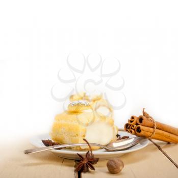 fresh homemade cream roll cake dessert and spices over white rustic wood table