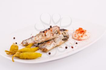 Fish, peppers  and cream on white plate.