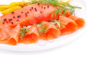 Salmon fillet with lemon, dill, pepper on plate.