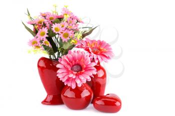 Flowers in vases and glass heart isolated on white background.