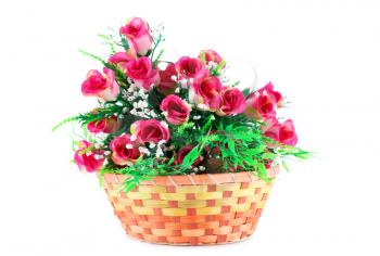 Pink fabric roses in wicker basket isolated on white background.