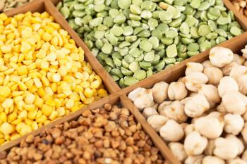 The collection of different groats, chickpea, pea and buckwheat in the wooden box.