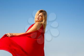 Blond woman in the red dress close up image.