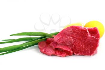 Cut of  beef steak with lemon slice and onion. Isolated.