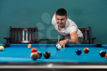 Young Men Lining To Hit Ball On Pool Table