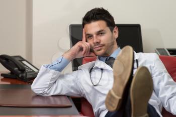 Young Doctor Relaxes Sitting In The Office