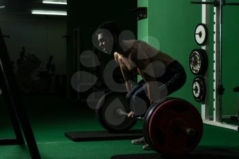 Muscular Man Lifting Dead Lift In The Gym