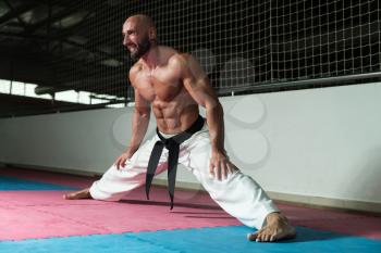 Male Martial Arts Instructor Preparing For Class - Warming Up and Stretching