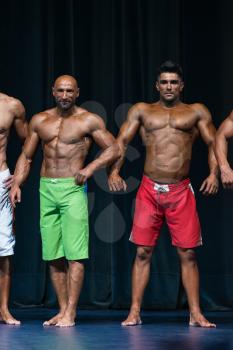 Mens Physique Posing During A Bodybuilding Competition