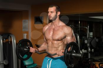 Young Athlete Doing Heavy Weight Exercise For Biceps
