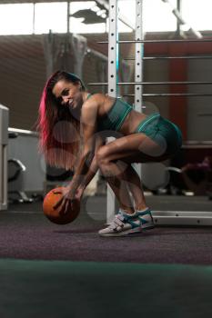 Young Woman Exercise With Medical Ball In Fitness Club
