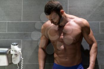 Portrait Of A Physically Fit Man Showing His Well Trained Body In A Bathroom