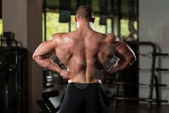 Man Standing Strong In The Gym And Flexing Muscles - Muscular Athletic Bodybuilder Fitness Model Posing After Exercises