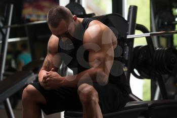 Big Bodybuilder Resting At The Bench In A Gym