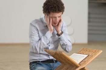Young Muslim Man Is Reading The Koran In The Mosque - Afro Lock Hair Curly
