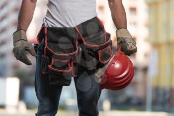 Close Up Of Hard Hat Holding By Construction Worker