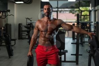 Portrait Of A Physically Italian Man Holding Weights In Hand