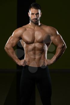 Healthy Man Standing Strong In The Gym And Flexing Muscles - Muscular Athletic Bodybuilder Fitness Model Posing After Exercises