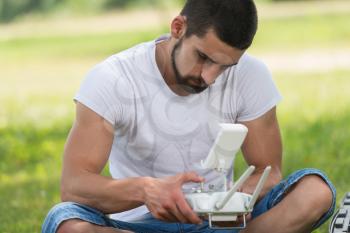 Young Engineer With Remote Control Preparing to Flying a Drone in Park