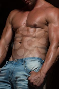 Close Up  Fit Man Showing His Well Trained Body - Muscular Athletic Bodybuilder Fitness Model Posing After Exercises On Wall of Bricks