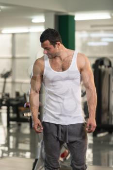 Portrait Of A Young Physically Fit Man In White Undershirt Showing His Well Trained Body - Muscular Athletic Bodybuilder Fitness Model Posing After Exercises