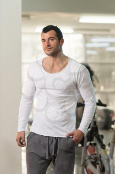 Handsome Young Man Standing Strong in White T-shirt and Flexing Muscles - Muscular Athletic Bodybuilder Fitness Model Posing After Exercises