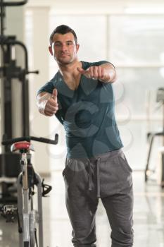Healthy Young Man in Green T-shirt Standing Strong and Flexing Muscles - Muscular Athletic Bodybuilder Fitness Model Posing After Exercises