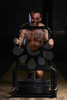 Bodybuilder Doing Heavy Weight Exercise Sled Push In Gym