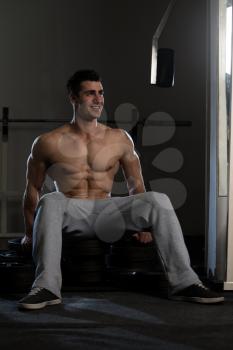 Resting Time - Confident Muscled Young Man Resting In Healthy Club Gym After Exercising