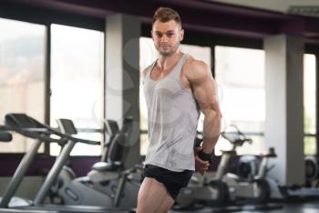 Healthy Man In Undershirt Standing Strong At Gym And Flexing Muscles - Muscular Athletic Bodybuilder Fitness Model Posing After Exercises