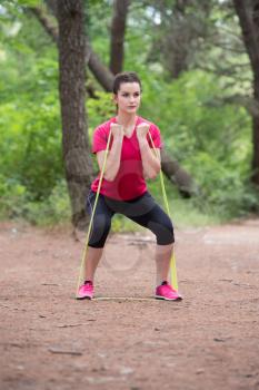 Young Woman Exercise with Resistance Band in Wooded Forest Area - Fitness Healthy Lifestyle Concept