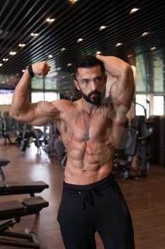 Portrait Of A Young Physically Fit Tattoo Man Showing His Well Trained Body - Muscular Athletic Bodybuilder Fitness Model Posing After Exercises