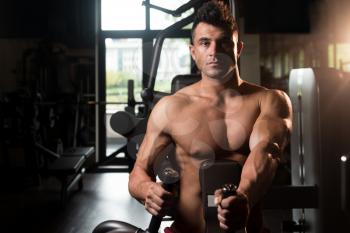 Muscular Man Doing Heavy Weight Exercise For Back On Machine