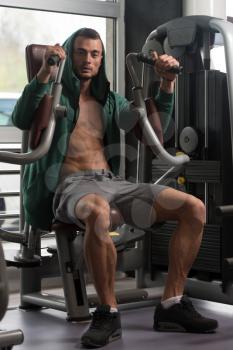 Handsome Muscular Fitness Bodybuilder Doing Heavy Weight Exercise For Chest On Machine With Cable In The Gym