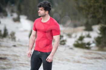 Portrait of a Young Physically Fit Man Showing His Well Trained Body While Wearing Black Jeans - Muscular Athletic Bodybuilder Fitness Model Posing Outdoors - a Place for Your Text
