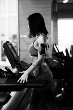 Young Woman Running On Treadmill In A Modern Fitness Center