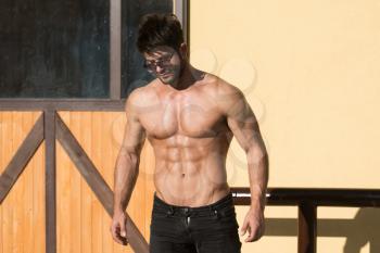 Portrait of a Young Physically Fit Man Showing His Well Trained Body While Wearing Black Jeans - Muscular Athletic Bodybuilder Fitness Model Posing After Exercises Outdoors - a Place for Your Text