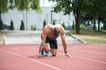 Sprinter Man Running on Red Tracks Lanes in Track and Field Stadium in High Speed Top View