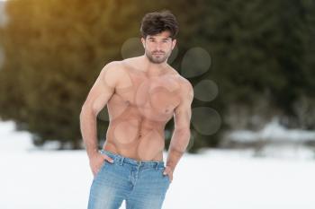 Portrait of a Young Physically Fit Man Showing His Well Trained Body While Wearing Blue Jeans - Muscular Athletic Bodybuilder Fitness Model Posing Outdoors - a Place for Your Text