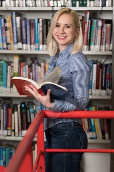 Pretty Female Student With Books Working in a High School Library