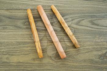 Horizontal photo of three wooden bread rollers on aged white ash wood boards