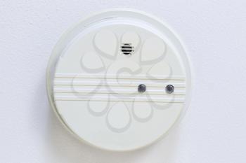 Horizontal photo of home smoke detector with white ceiling background