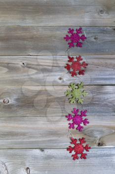 Vertical view of Christmas Ornament Snowflakes on rustic wood 